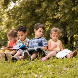 Kids reading in grass