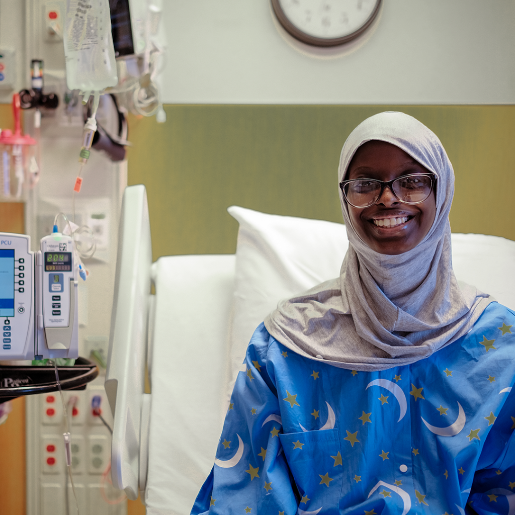 A patient in a hospital bed wearing a modesty gown