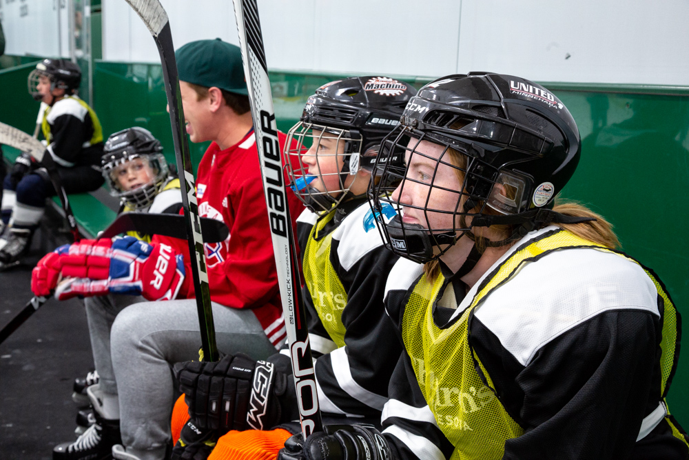 Two boys in yellow jerseys looking at a hockey rink
