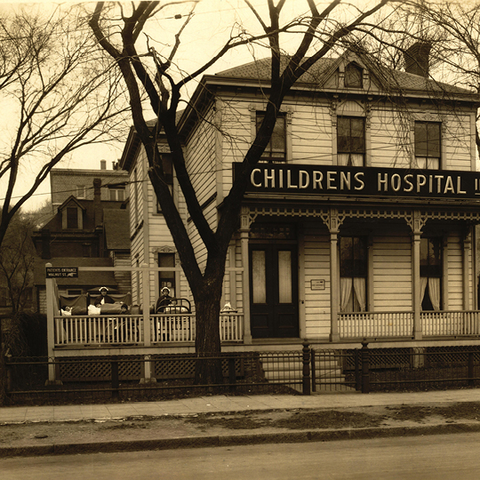 an early 1900s house with a sign above the front door that says, "Children's Hospital Inc."