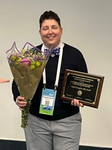 Dr. Angela Kade Goepferd, (they/she), medical director of the Gender Health program at Children’s Minnesota, holding their Ellen Perrin Award for Excellence in LGBTQ+ Health and Wellness from the American Academy of Pediatrics Section on LGBT Health and Wellness