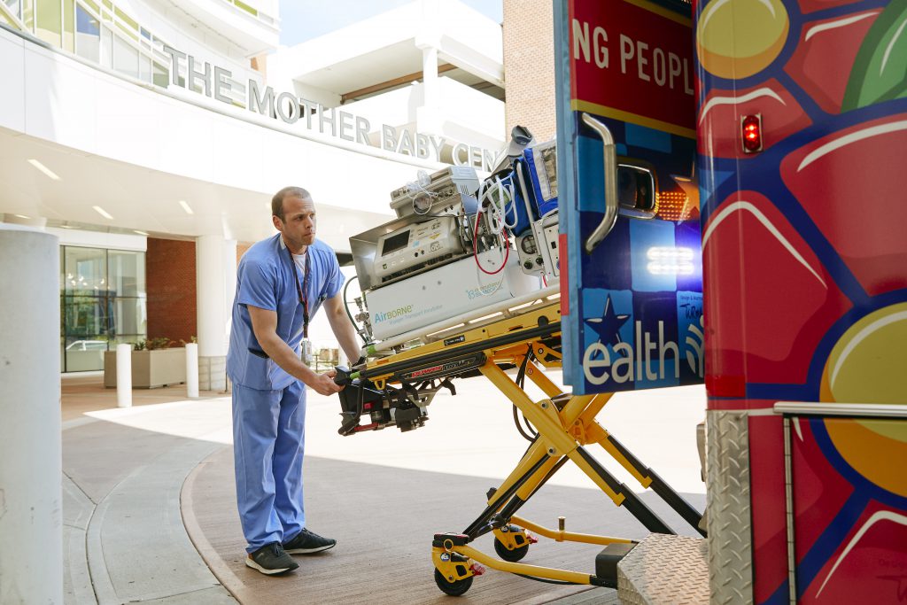 Andy Rowe putting a stretcher into a Children's Minnesota ambulance.