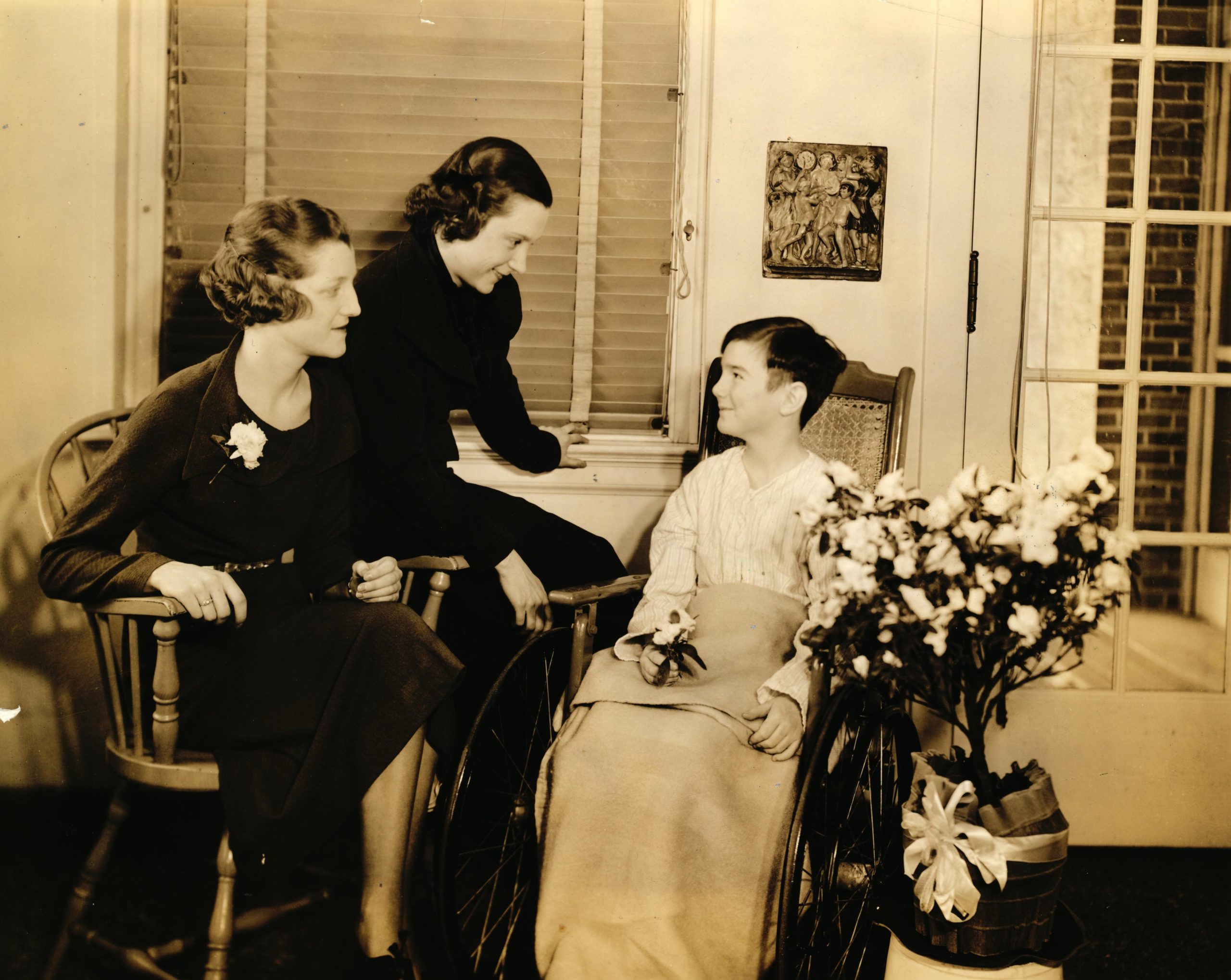 Children's Hospital Association members visit a boy, circa 1930s.