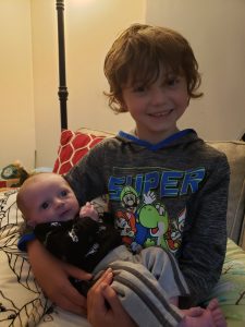 Baby August being held by brother