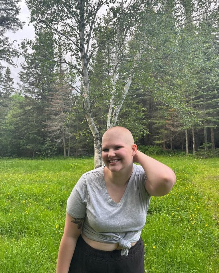 Kayla outside smiling with her head shaved
