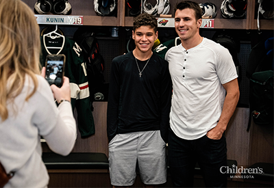 Minnesota Wild forward Zach Parise with a Children's Minnesota patient smiling in the lockerroom