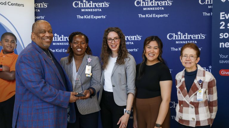Children's Minnesota and Memorial Blood Centers representatives pose for a picture with the award.