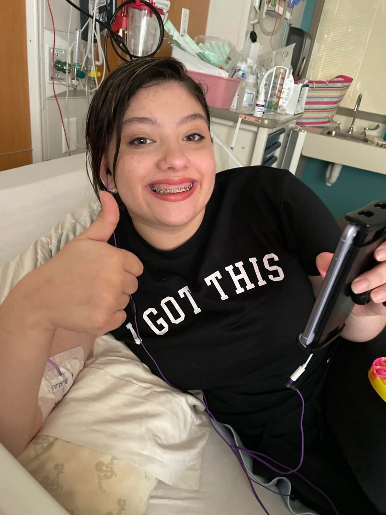 Kaili smiles in the hospital with a 'I got this' shirt.