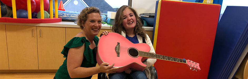 Addison and Miss Nina posing with a pink guitar