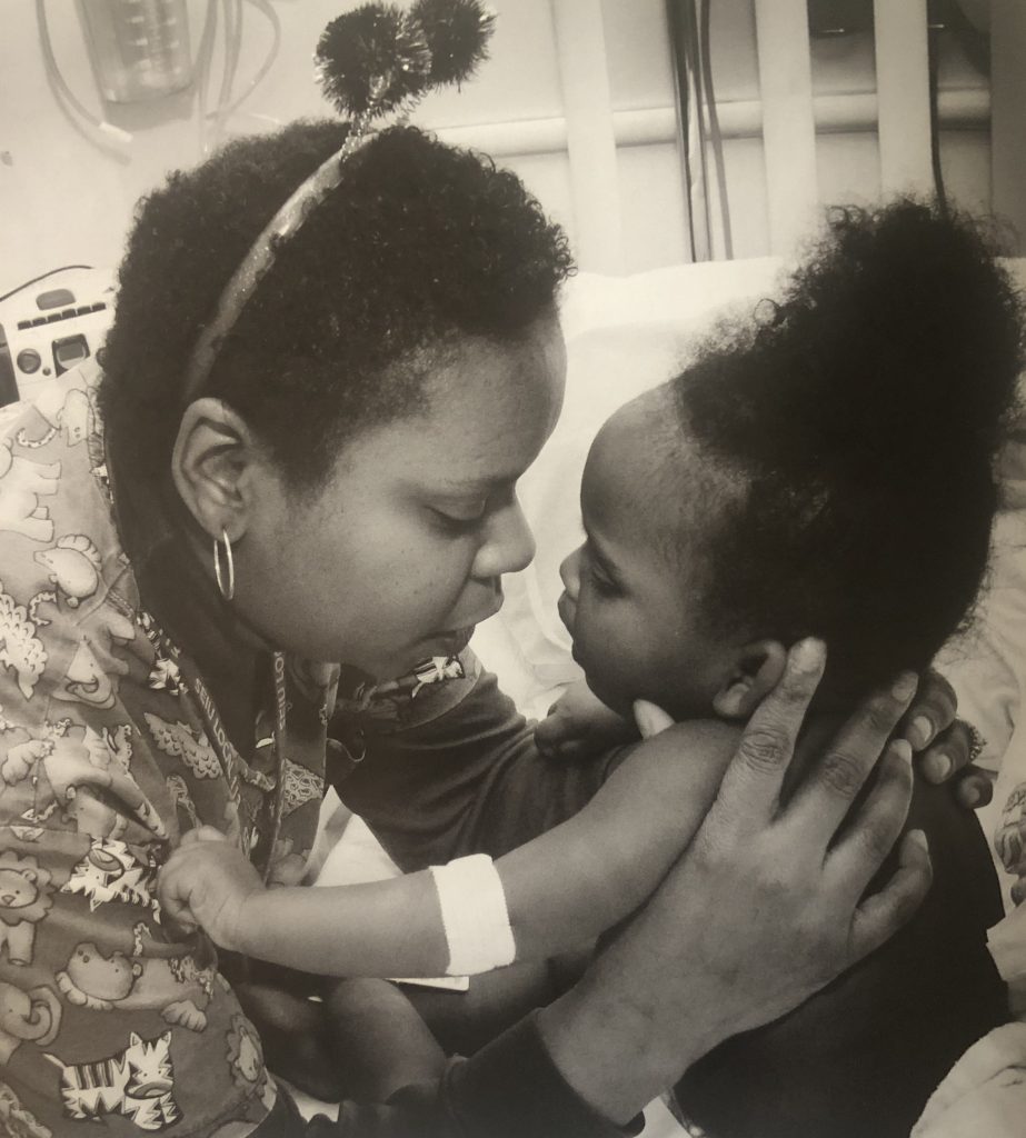 Photo of a nurse holding a small child.