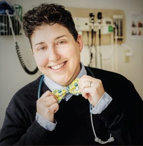Angela Kade Goepferd, MD, smiling and holding on to her bowtie