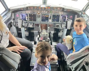 Alexa and her brother in the plane by the pilot