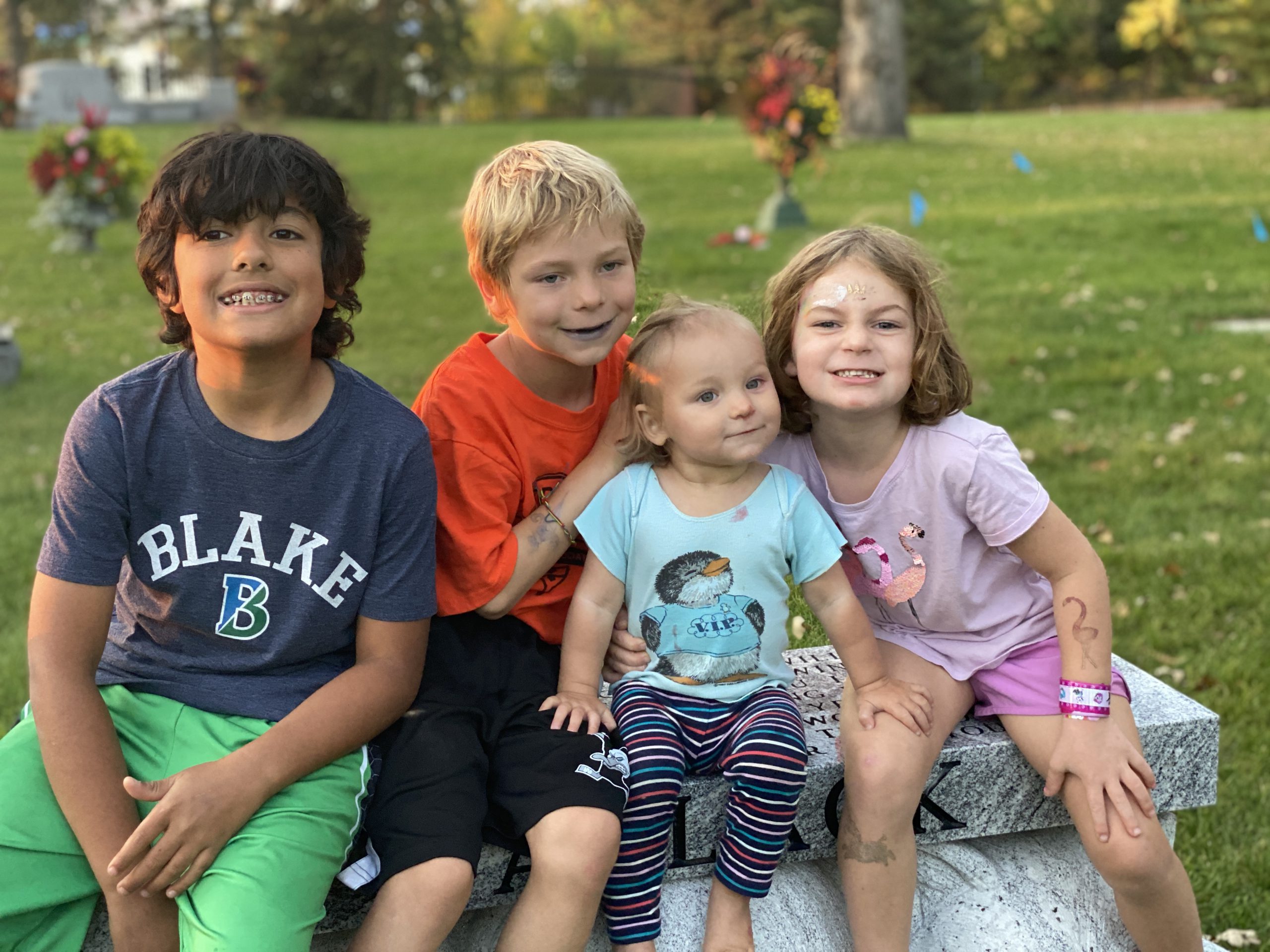 The Wyrobek kids sit smiling at a park