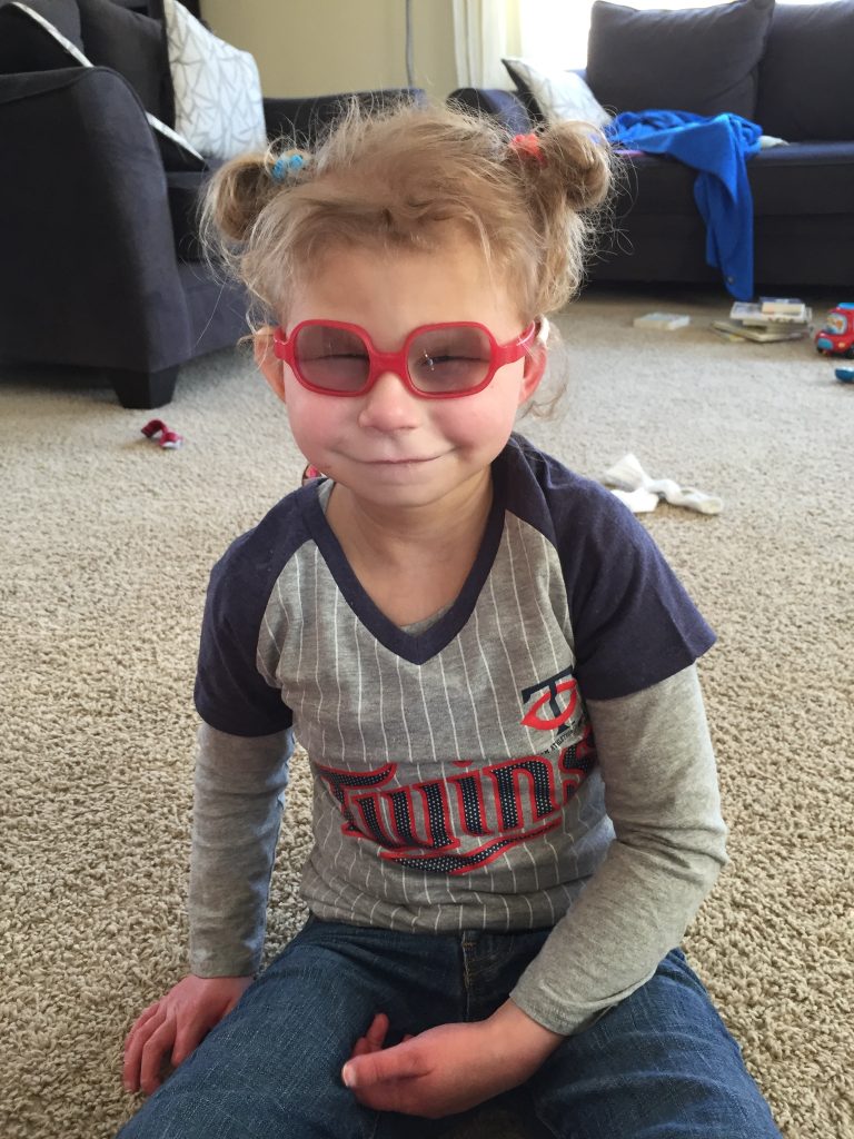 Anna at home smiling in a Minnesota Twins shirt