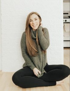 Ashley sitting on the floor smiling