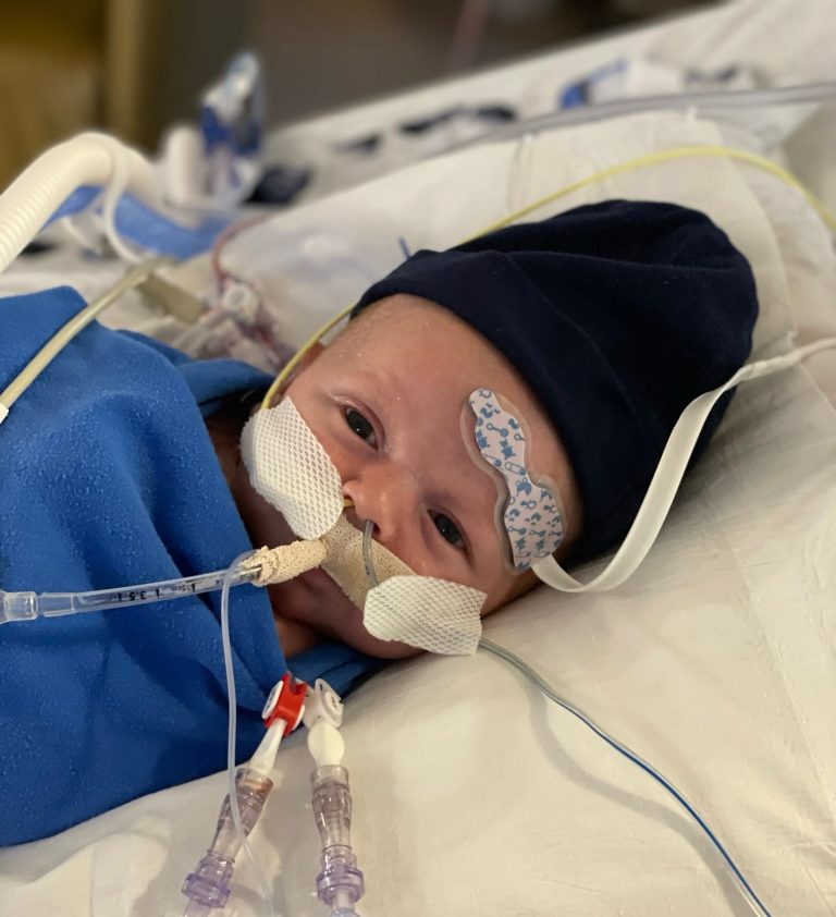 Ollie as a baby in a hospital bed.
