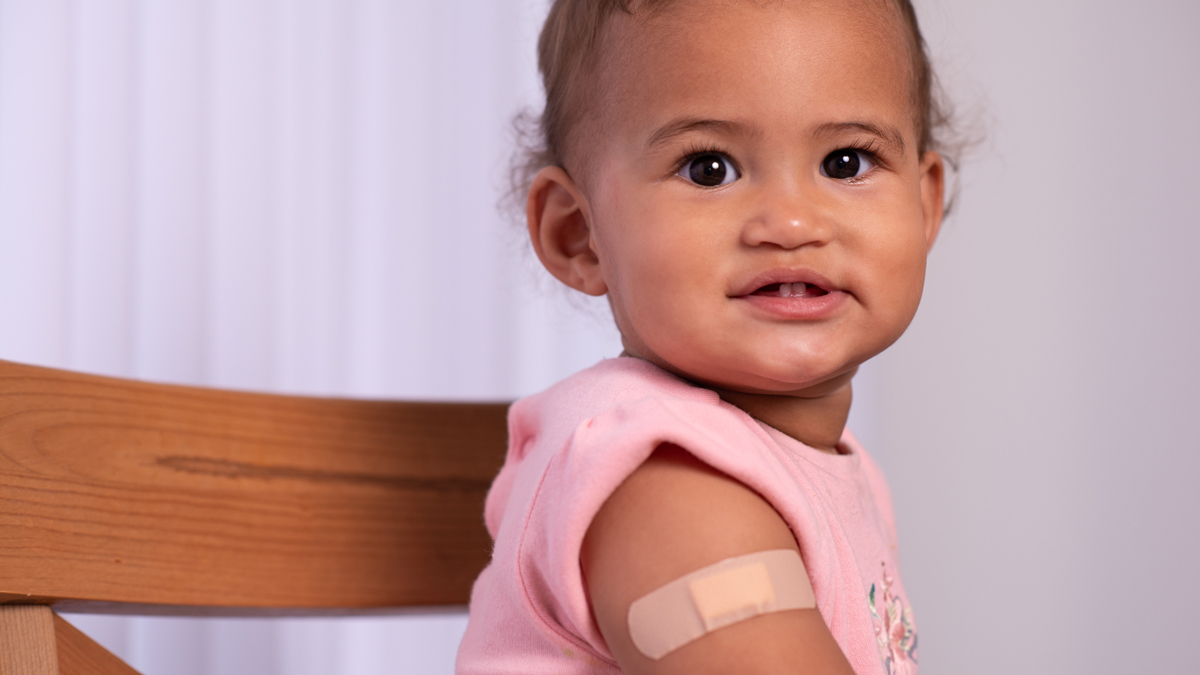 baby with band-aid on arm