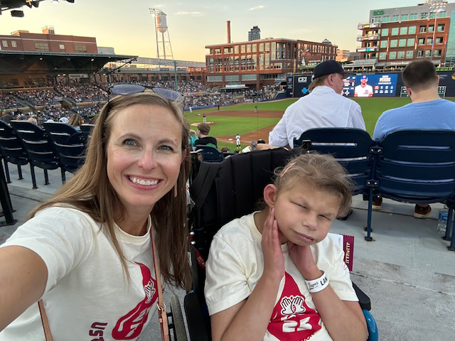 Mom and daughter outside at baseball game