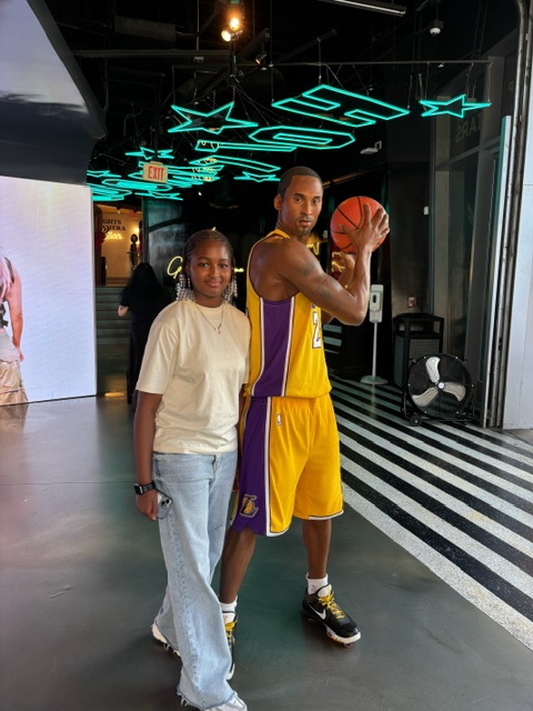 Binta posing with a statue of Kobe Bryant.