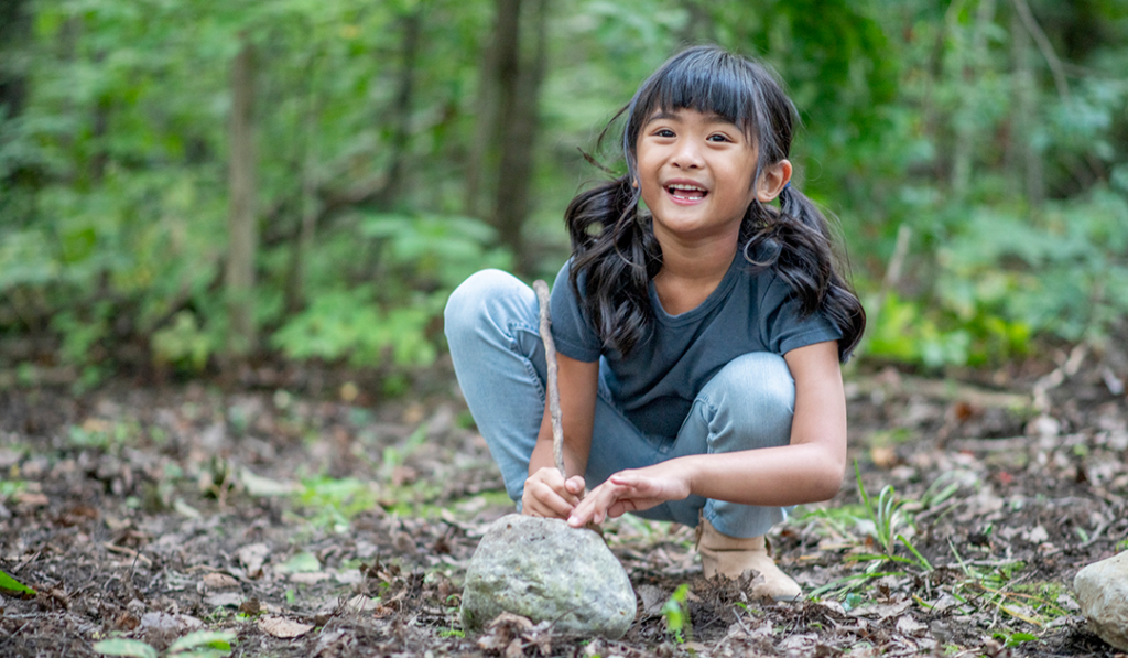 Child enjoying nature play, learning wilderness skills