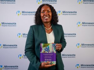 Caroline Njau holding her MHA award plaque.