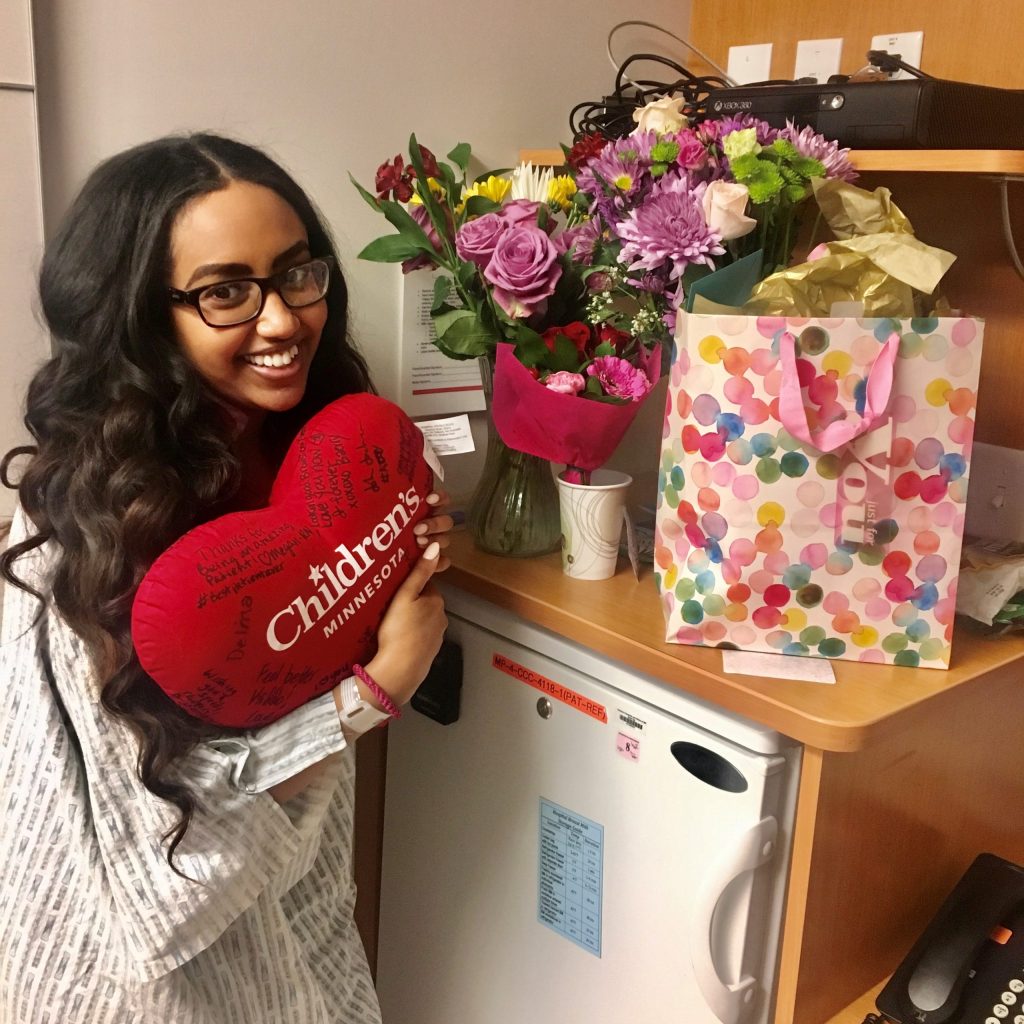 Delina holding a stuffed heart and flowers