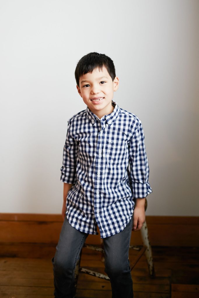 Colin taking a photo standing up in a checkered shirt
