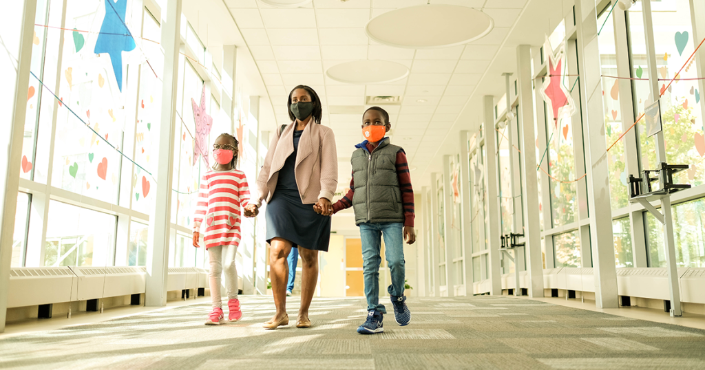 Family walking into Children's Minnesota with masks on.