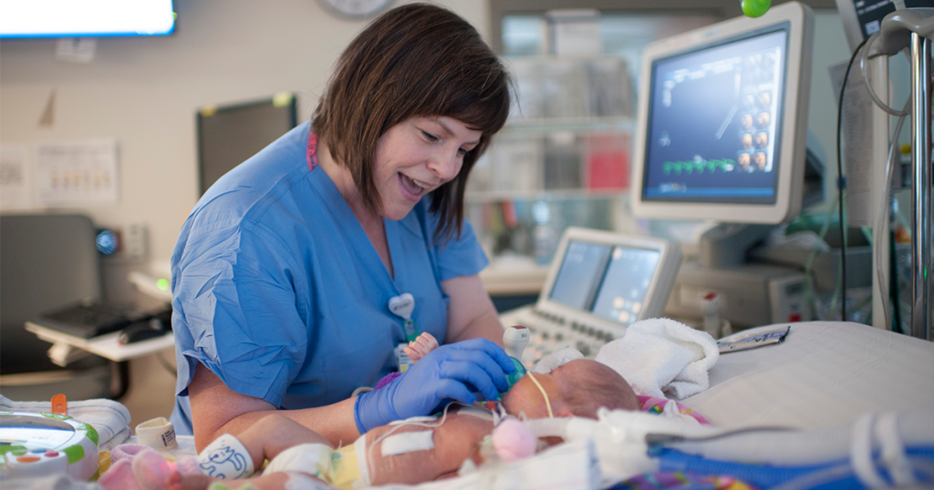 Cardiology nurse interacts with infant patient