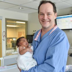 Dr. Moga holds a baby, one of the patients in the Children's Minnesota cardiovascular department