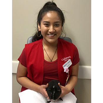 Photo of Cynthia M, volunteer at Children's Minnesota in a red vest