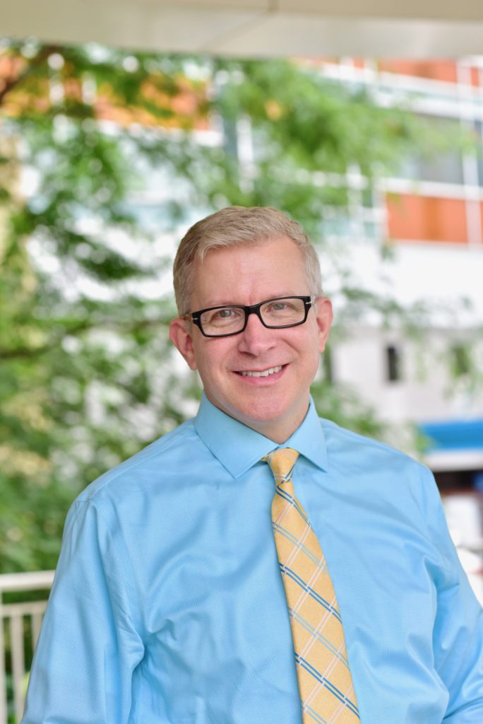 Dr. David Gregornik, PharmD, standing outside smiling in front of a tree