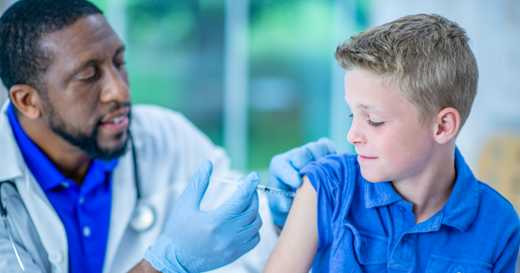 Doctor giving 11-year-old boy a vaccine