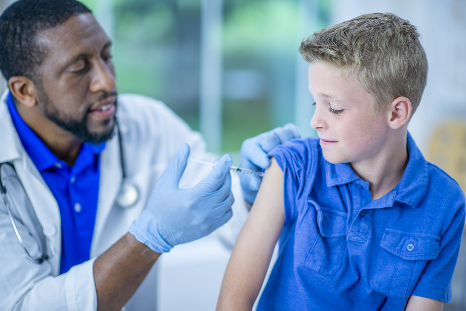 Doctor giving 11-year-old boy a vaccine