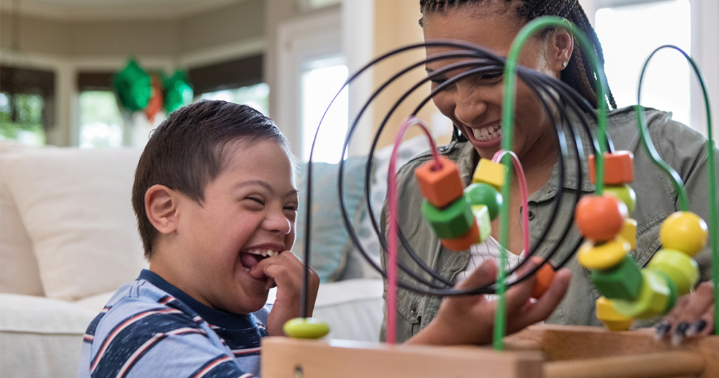 Child with Down syndrome playing bead maze with mom