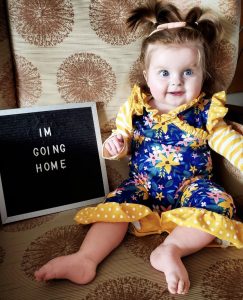 Evelyn posing with a picture that says "I'm going home."