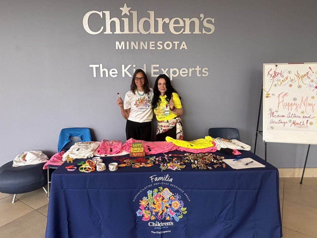 Two members of the Familia employee resource group at a table giving away candy