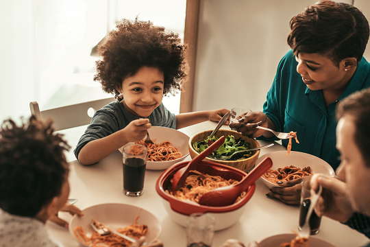 family of four having dinner together at home