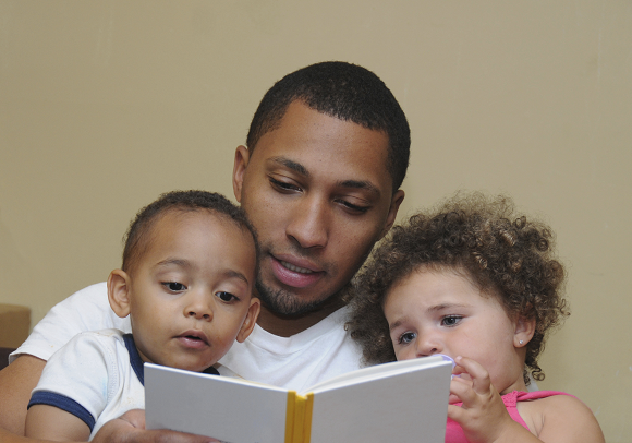 Father reading to young son and daughter