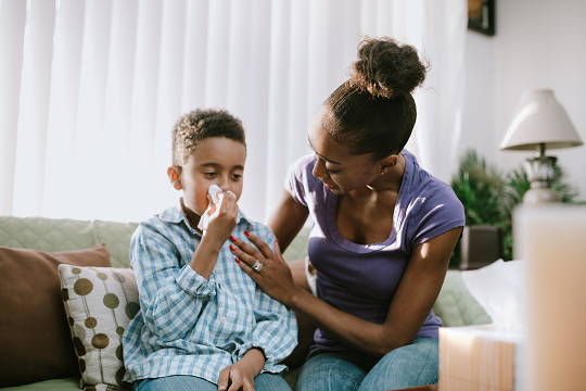 mother comforts son with the flu
