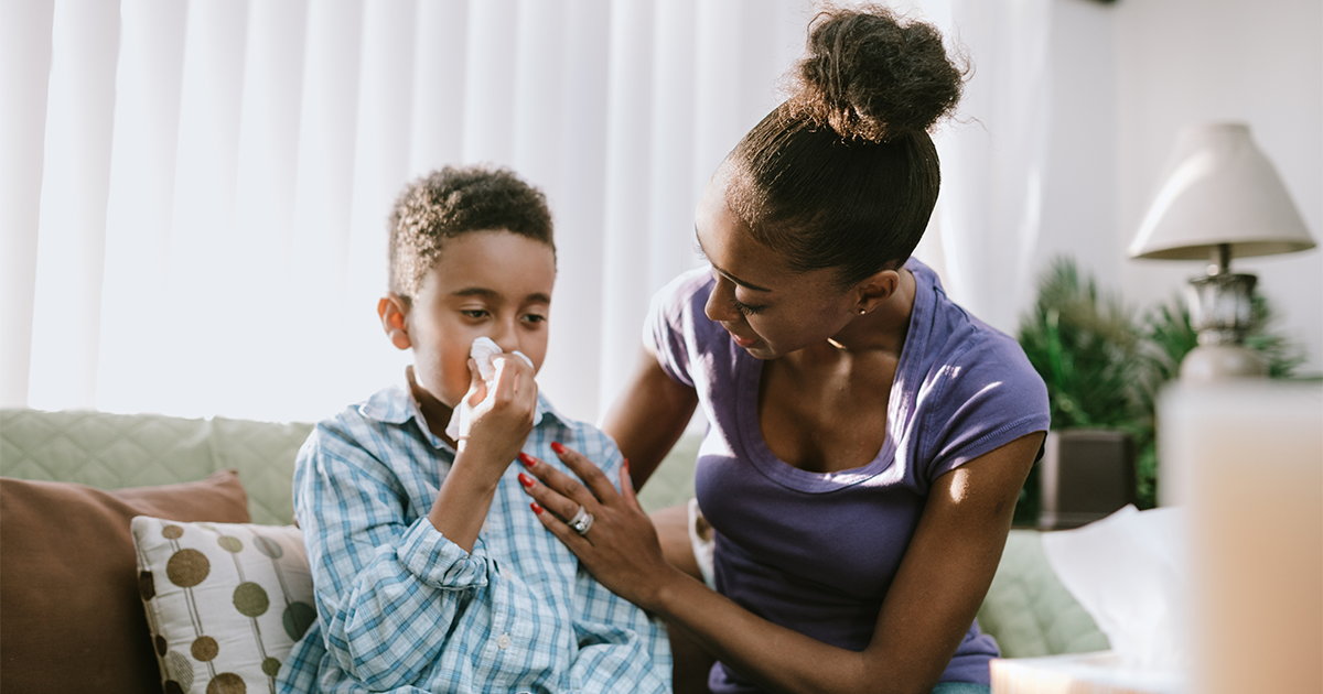 mother comforts son with the flu