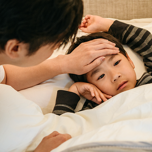 kid laying in bed sick