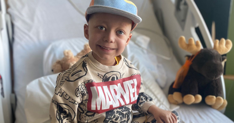 Young boy in a hospital bed and smiling