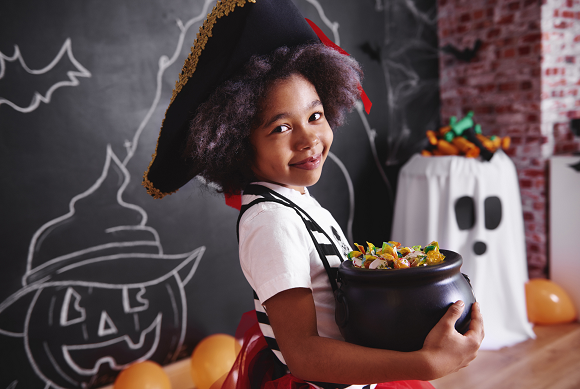 Girl wearing pirate costume holding a bowl of candy|Girl wearing pirate costume holding a bowl of candy|Girl wearing pirate costume holding a bowl of candy