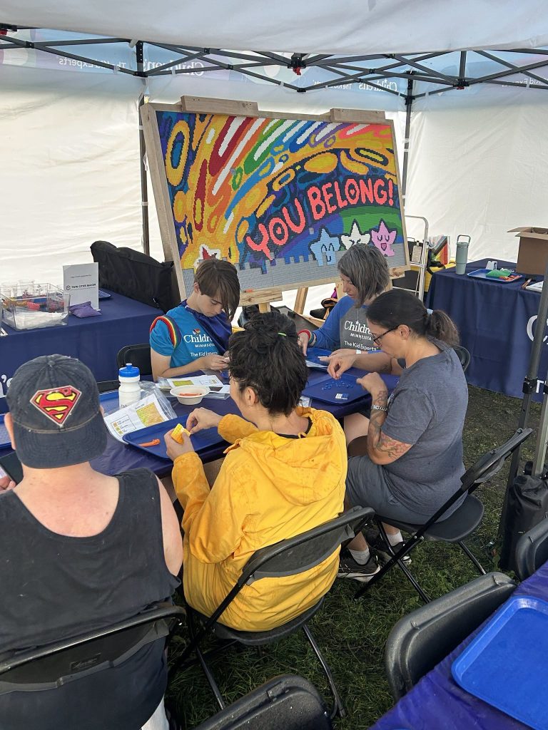A group of people working on building a LEGO mural for Pride