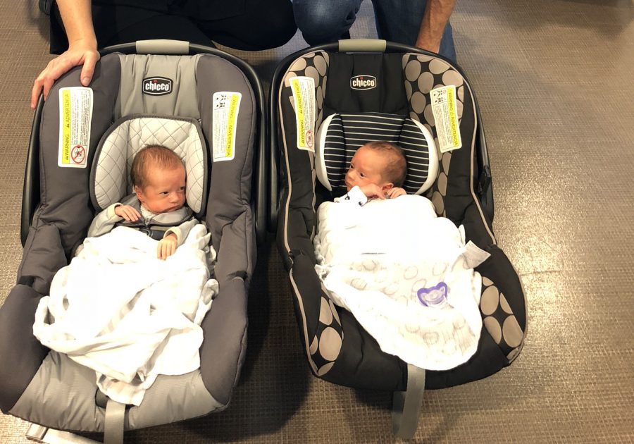 Twins heading home from the NICU in car seats.