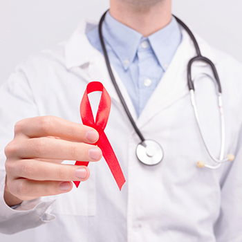 doctor holding HIV testing awareness ribbon||doctor holding HIV testing awareness ribbon