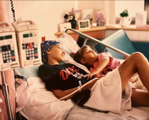 Jen and another kid laying in hospital bed