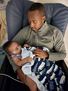 PJ Hill holding his son PJ Jr.