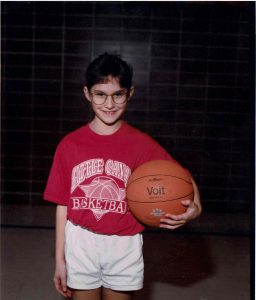 Jen Pratt as a child holds a basketball